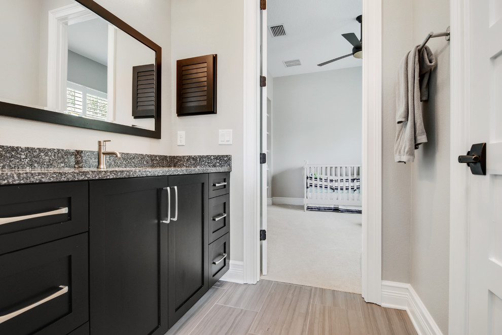 Example of a mid-sized transitional 3/4 black and white tile and porcelain tile porcelain tile and beige floor bathroom design in Tampa with shaker cabinets, black cabinets, beige walls, an undermount sink and granite countertops