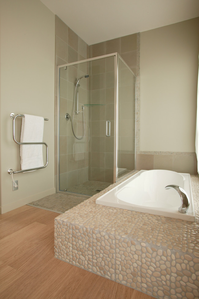 Modelo de cuarto de baño principal marinero con bañera encastrada, ducha esquinera, baldosas y/o azulejos beige, suelo de baldosas tipo guijarro y paredes blancas