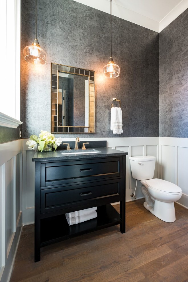 Foto di una stanza da bagno tradizionale con ante nere, WC a due pezzi, pareti grigie, parquet scuro, lavabo sottopiano, pavimento marrone, top grigio e ante con riquadro incassato