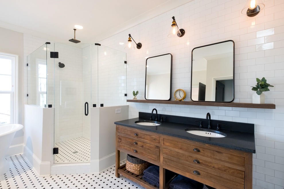Стильный дизайн: главная ванная комната в стиле неоклассика (современная классика) с темными деревянными фасадами, отдельно стоящей ванной, угловым душем, белой плиткой, плиткой кабанчик, белыми стенами, полом из мозаичной плитки, врезной раковиной, разноцветным полом, душем с распашными дверями, черной столешницей и плоскими фасадами - последний тренд