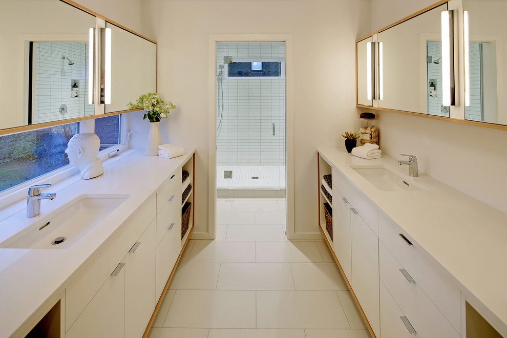 Idéer för ett modernt badrum med dusch, med ett undermonterad handfat, släta luckor, vita skåp, en dusch i en alkov, vit kakel och vita väggar