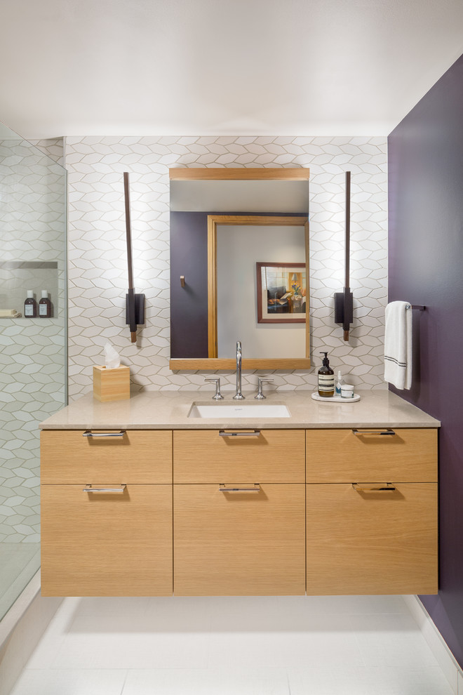 Corner shower - mid-sized contemporary 3/4 beige tile and ceramic tile corner shower idea in Portland with flat-panel cabinets, light wood cabinets, purple walls, an undermount sink and quartz countertops