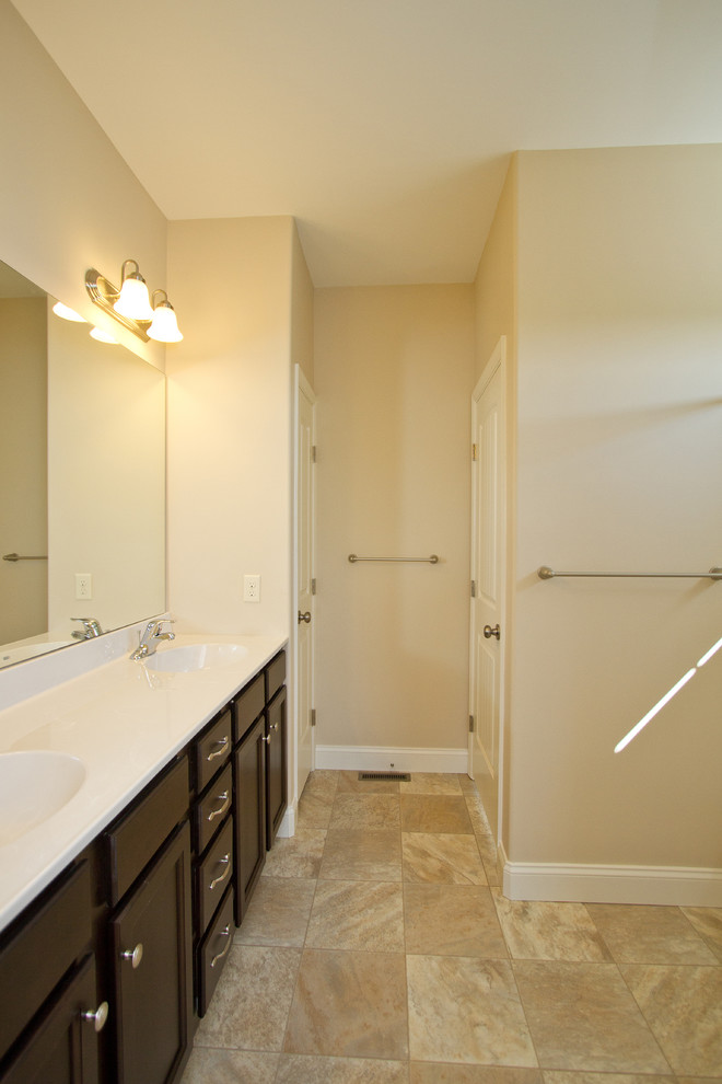 Imagen de cuarto de baño clásico pequeño con armarios con paneles con relieve, puertas de armario de madera en tonos medios, encimera de acrílico, combinación de ducha y bañera, paredes beige y suelo de linóleo