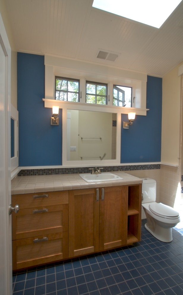 Immagine di una piccola stanza da bagno padronale stile americano con lavabo da incasso, ante in stile shaker, ante in legno scuro, top piastrellato, vasca ad alcova, vasca/doccia, WC a due pezzi, piastrelle blu, pareti blu e pavimento con piastrelle in ceramica