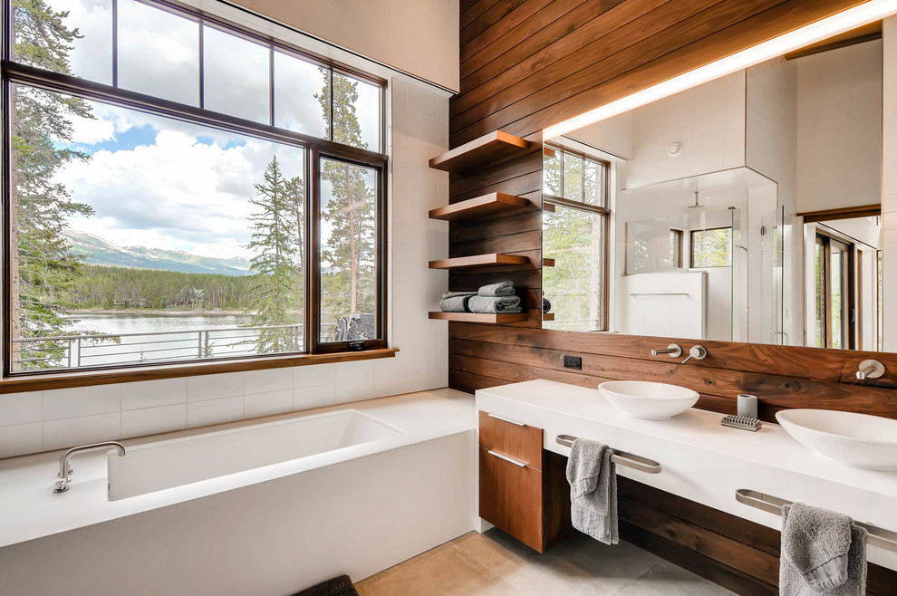 Freestanding bathtub - large contemporary master white tile beige floor freestanding bathtub idea in Denver with flat-panel cabinets, white cabinets, brown walls, a vessel sink and solid surface countertops