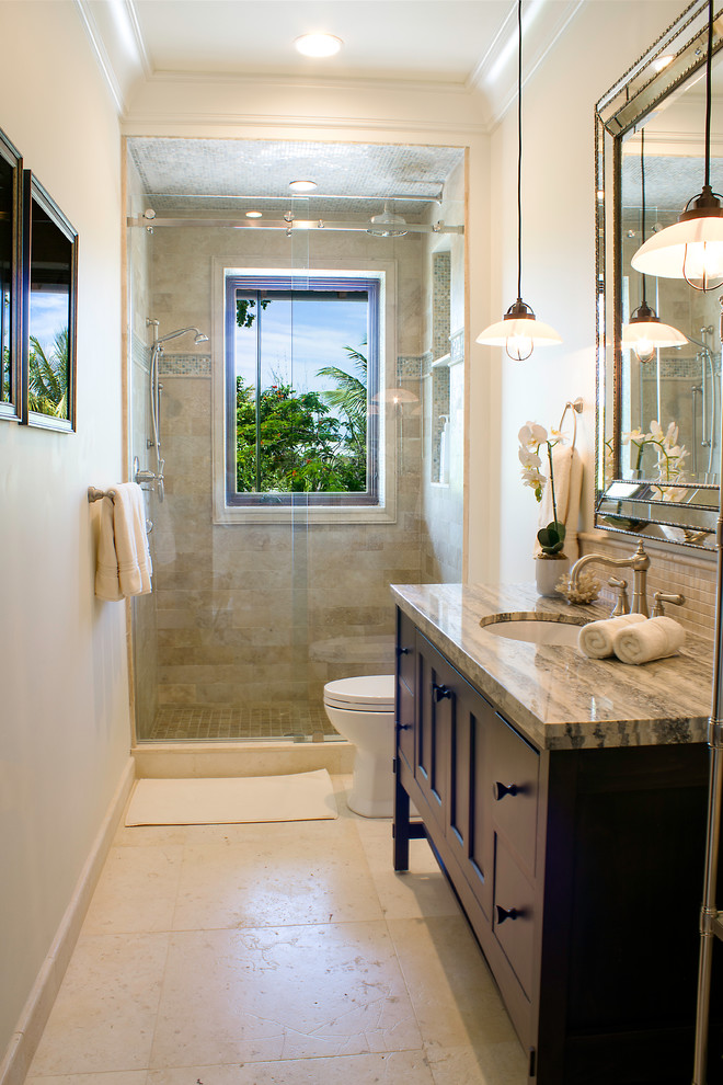 Design ideas for a medium sized world-inspired shower room bathroom in Miami with brown cabinets, beige tiles, beige walls, recessed-panel cabinets, an alcove shower, a two-piece toilet, metro tiles, travertine flooring, a built-in sink, granite worktops, beige floors and a sliding door.