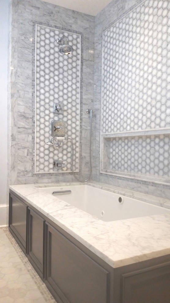 Exemple d'une salle de bain principale chic de taille moyenne avec un placard avec porte à panneau encastré, des portes de placard grises, une baignoire encastrée, un combiné douche/baignoire, WC séparés, un carrelage gris, un carrelage de pierre, un mur bleu, un sol en marbre, un lavabo encastré et un plan de toilette en marbre.