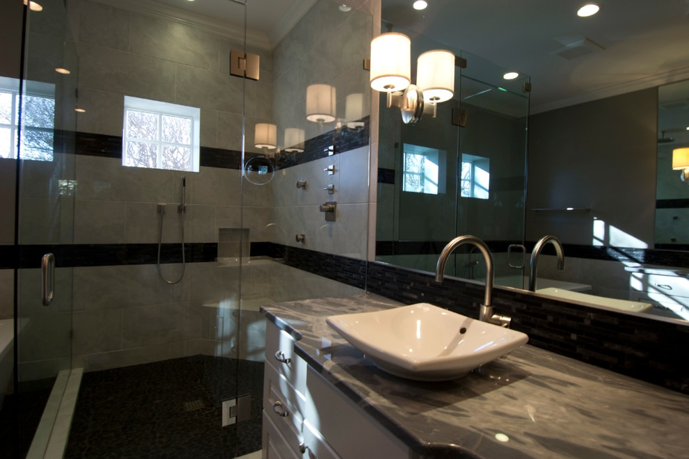 Пример оригинального дизайна: большая главная ванная комната в стиле неоклассика (современная классика) с настольной раковиной, фасадами с выступающей филенкой, белыми фасадами, мраморной столешницей, отдельно стоящей ванной, угловым душем, унитазом-моноблоком, серой плиткой, удлиненной плиткой, серыми стенами и полом из керамогранита