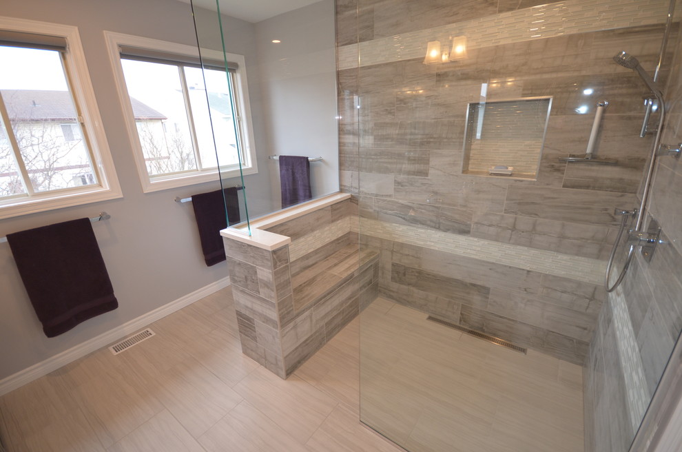 This is an example of a contemporary ensuite half tiled bathroom in Ottawa with recessed-panel cabinets, grey cabinets, a built-in shower, a two-piece toilet, grey tiles, porcelain tiles, porcelain flooring, a submerged sink, engineered stone worktops, grey walls, beige floors and an open shower.