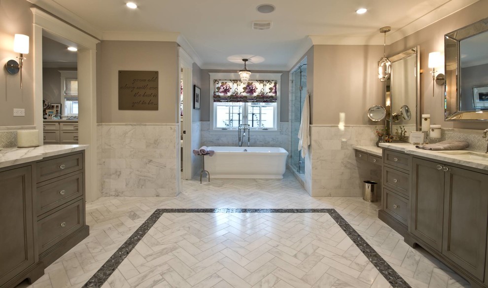 Bild på ett mycket stort vintage en-suite badrum, med luckor med infälld panel, grå skåp, ett fristående badkar, en dusch i en alkov, grå kakel, vit kakel, marmorkakel, grå väggar, marmorgolv, ett undermonterad handfat, marmorbänkskiva, grått golv och dusch med gångjärnsdörr