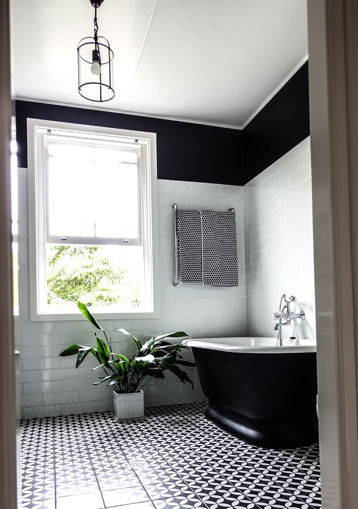 Стильный дизайн: большая главная ванная комната в стиле кантри с фасадами с выступающей филенкой, черными фасадами, отдельно стоящей ванной, угловым душем, унитазом-моноблоком, белой плиткой, керамической плиткой, черными стенами, полом из керамической плитки, накладной раковиной, мраморной столешницей, черным полом, душем с распашными дверями и белой столешницей - последний тренд