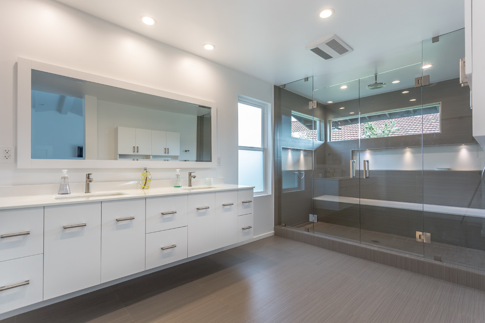 Design ideas for a large modern ensuite bathroom in Los Angeles with grey cabinets, brown tiles, white walls, ceramic flooring, an integrated sink, engineered stone worktops, flat-panel cabinets, an alcove shower, porcelain tiles, brown floors and a hinged door.
