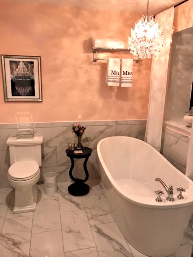 Aménagement d'une petite salle de bain principale romantique avec une baignoire indépendante, un mur jaune, un sol en marbre et un sol blanc.