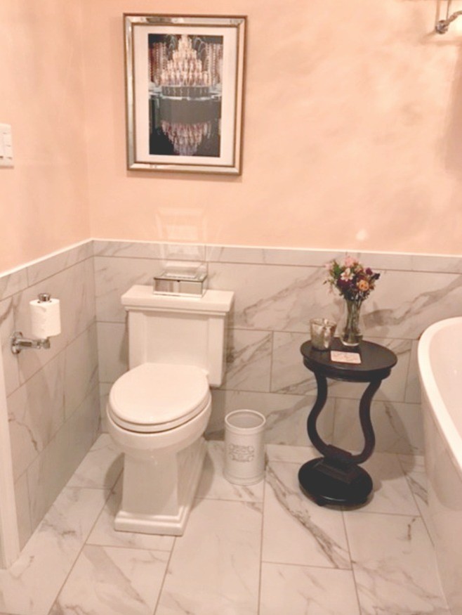 Kleine Shabby-Style Gästetoilette mit offenen Schränken, weißen Fliesen, Steinfliesen, gelber Wandfarbe, Marmorboden, Sockelwaschbecken, Mineralwerkstoff-Waschtisch und weißem Boden in Sonstige