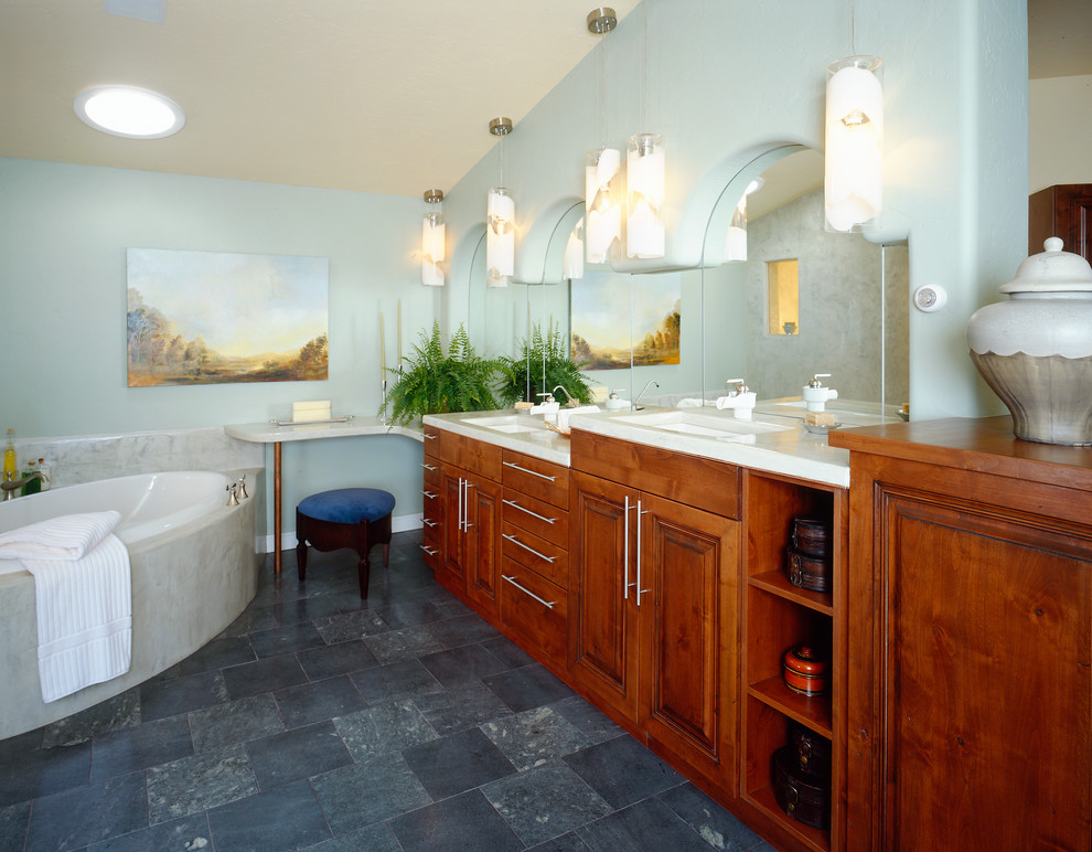 Aménagement d'une salle de bain principale contemporaine en bois brun de taille moyenne avec un placard avec porte à panneau encastré, un plan de toilette en stéatite, une baignoire encastrée, un mur bleu, un sol en carrelage de céramique, un lavabo encastré et un sol gris.
