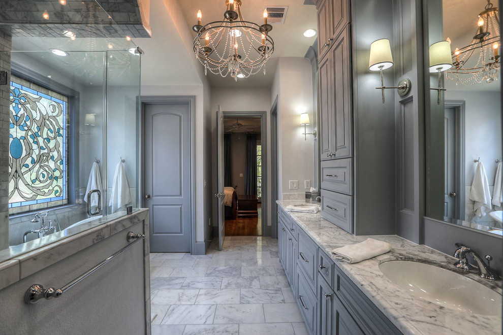 Klassisk inredning av ett stort en-suite badrum, med luckor med upphöjd panel, grå skåp, ett badkar med tassar, en hörndusch, vit kakel, marmorkakel, vita väggar, marmorgolv, ett undermonterad handfat och marmorbänkskiva