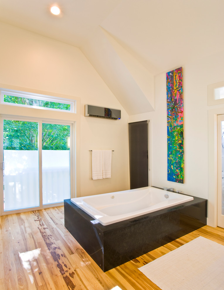 他の地域にあるコンテンポラリースタイルのおしゃれな浴室 (アンダーマウント型浴槽、黒いタイル) の写真