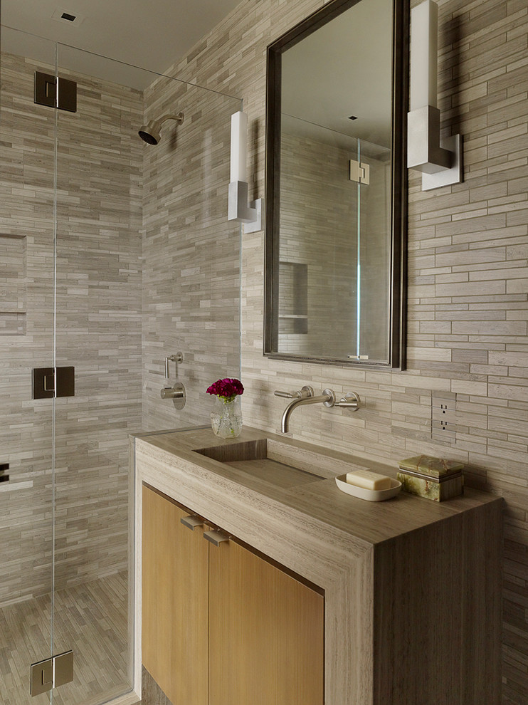 Foto di una stanza da bagno contemporanea con lavabo integrato, ante lisce, ante in legno scuro, doccia alcova, piastrelle grigie e piastrelle in pietra