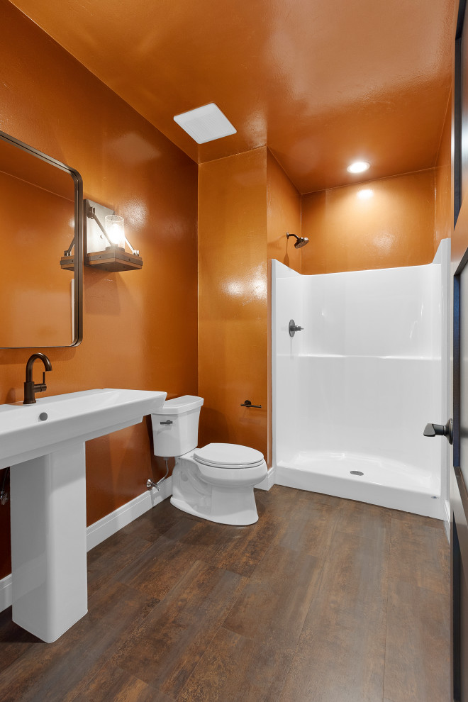 Immagine di una stanza da bagno con doccia chic di medie dimensioni con ante in stile shaker, WC a due pezzi, pareti arancioni, pavimento in vinile, lavabo a colonna e un lavabo