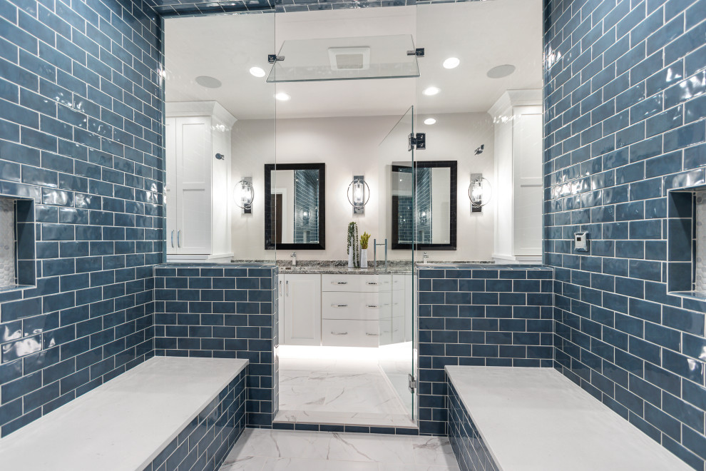 Идея дизайна: большая главная ванная комната в стиле неоклассика (современная классика) с фасадами в стиле шейкер, желтыми фасадами, раздельным унитазом, синей плиткой, плиткой кабанчик, белыми стенами, полом из керамогранита, врезной раковиной, столешницей из гранита, белым полом, душем с распашными дверями, разноцветной столешницей, сиденьем для душа, тумбой под две раковины и встроенной тумбой