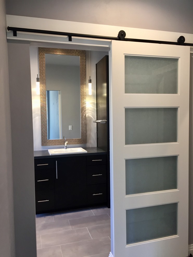 Modern inredning av ett en-suite badrum, med släta luckor, bruna skåp, klinkergolv i keramik, ett fristående handfat, laminatbänkskiva och grått golv