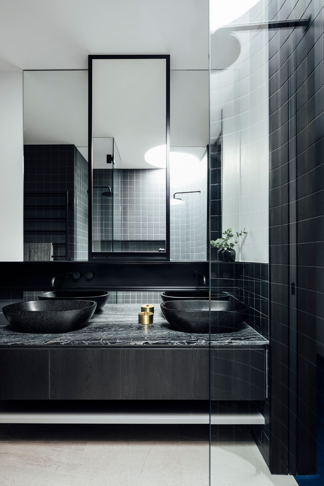 Imagen de cuarto de baño principal contemporáneo con baldosas y/o azulejos negros, paredes blancas, lavabo sobreencimera, suelo gris, encimeras negras, armarios con paneles lisos y puertas de armario negras