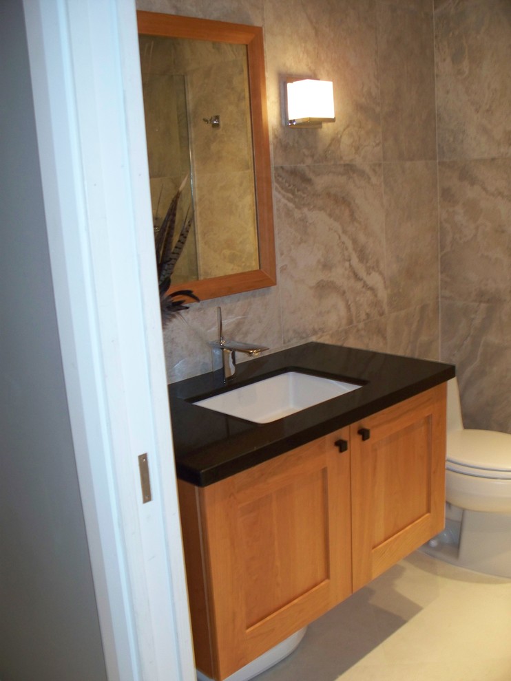 Réalisation d'une petite salle de bain tradition en bois clair avec un placard à porte shaker, WC à poser, un carrelage de pierre, un mur violet, un sol en carrelage de porcelaine, un lavabo encastré et un plan de toilette en surface solide.