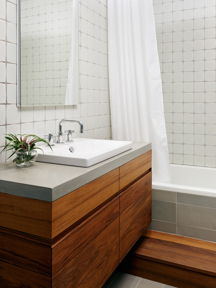 Modern inredning av ett badrum, med bänkskiva i betong och dusch med duschdraperi