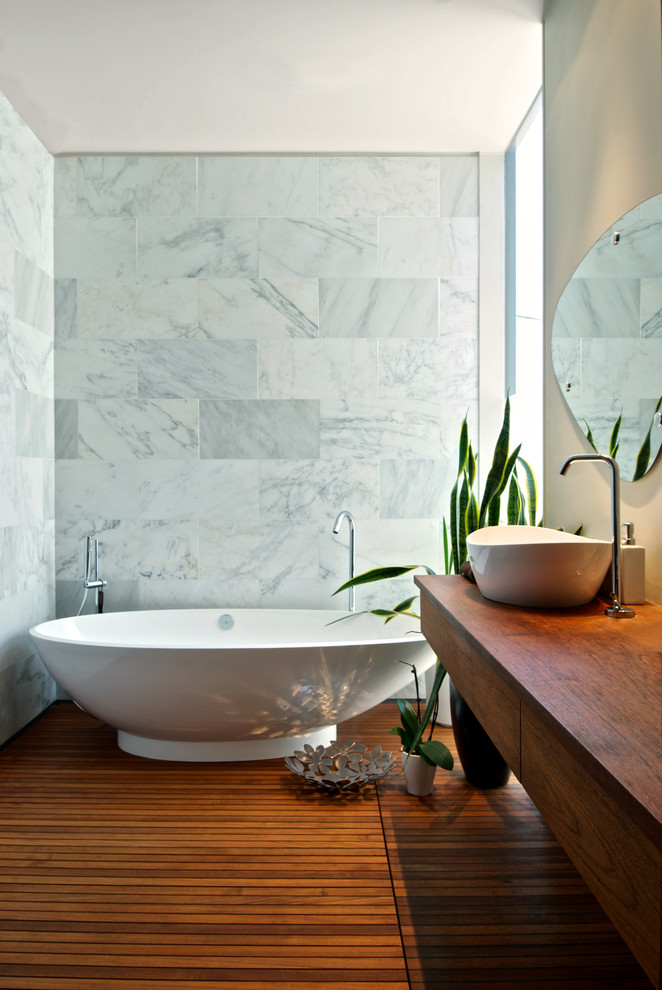 Пример оригинального дизайна: ванная комната в современном стиле с душем без бортиков, отдельно стоящей ванной, настольной раковиной, столешницей из дерева и коричневой столешницей