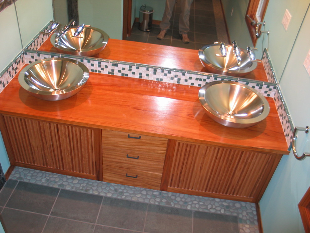 Foto di una stanza da bagno mediterranea con ante lisce, ante in legno chiaro e top in granito