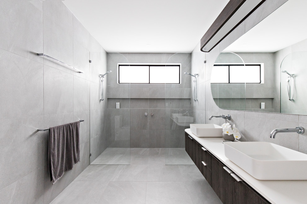 Пример оригинального дизайна: ванная комната в современном стиле с плоскими фасадами, темными деревянными фасадами, серой плиткой, настольной раковиной, серым полом, открытым душем, белой столешницей и двойным душем