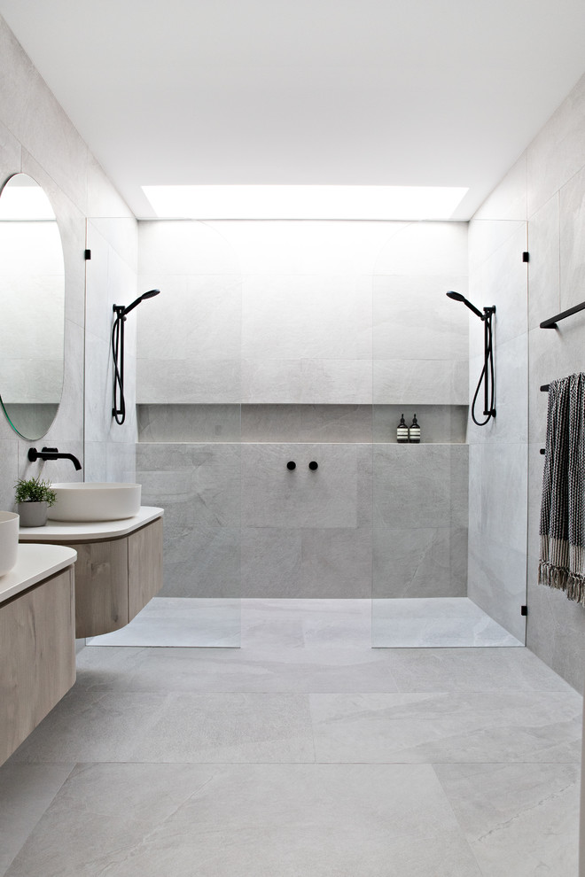 Immagine di una stanza da bagno contemporanea con ante lisce, ante in legno chiaro, piastrelle grigie, lavabo a bacinella, pavimento grigio, doccia aperta, top beige e doccia doppia