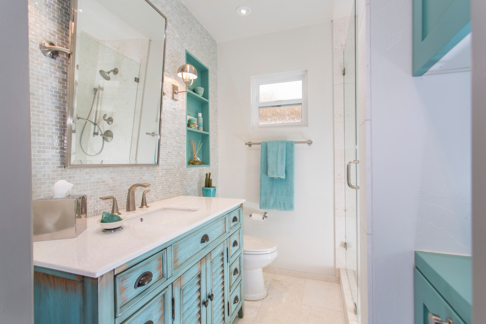 Exemple d'une salle de bain de taille moyenne avec un placard en trompe-l'oeil, des portes de placard turquoises, mosaïque, un sol en calcaire, un lavabo encastré, un plan de toilette en calcaire, un sol beige, un plan de toilette blanc, meuble simple vasque et meuble-lavabo sur pied.