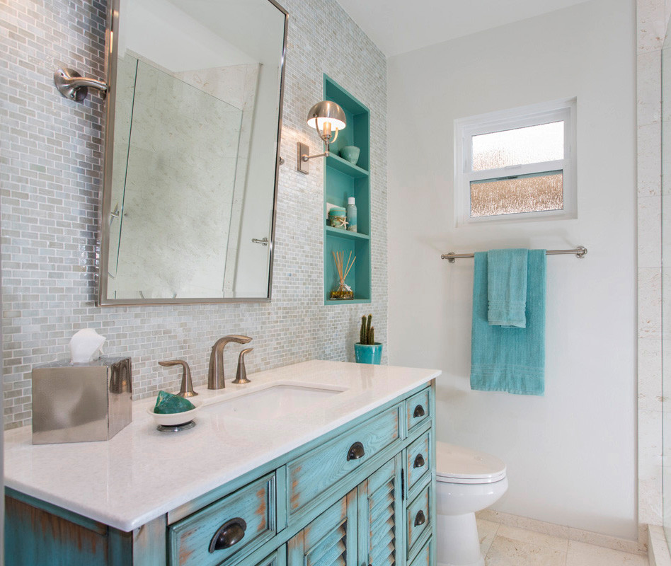 Mid-sized beach style beige tile limestone floor, beige floor and single-sink bathroom photo in San Diego with furniture-like cabinets, turquoise cabinets, white walls, an undermount sink, limestone countertops, white countertops and a freestanding vanity
