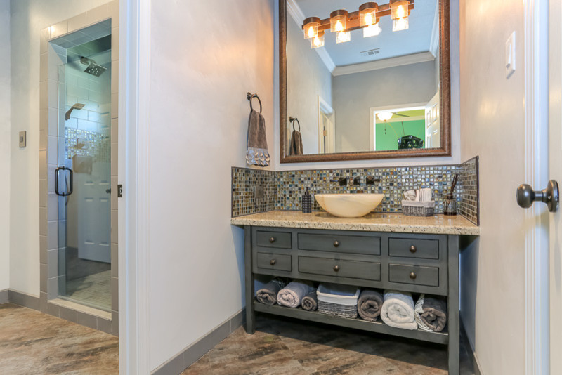 Ejemplo de cuarto de baño principal bohemio grande con lavabo sobreencimera, armarios tipo mueble, puertas de armario con efecto envejecido, encimera de granito, ducha empotrada, baldosas y/o azulejos multicolor, baldosas y/o azulejos de vidrio y paredes grises