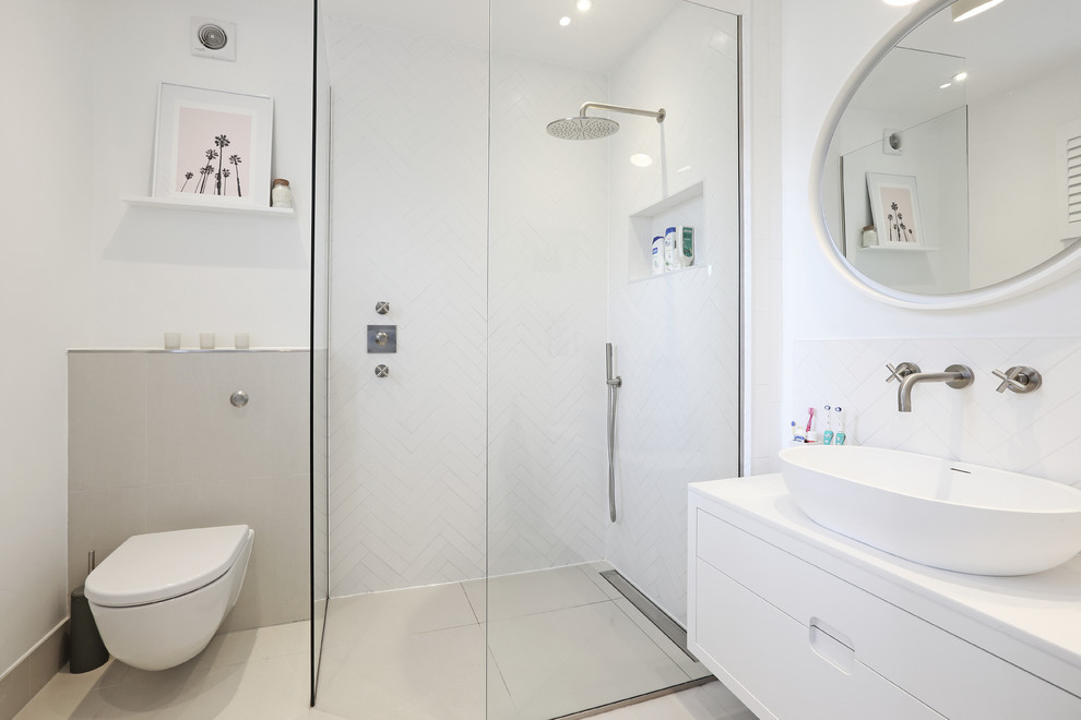Photo of a small contemporary shower room bathroom in London with flat-panel cabinets, a wall mounted toilet, white tiles, white walls, a vessel sink, beige floors, an open shower, white worktops, white cabinets and a walk-in shower.