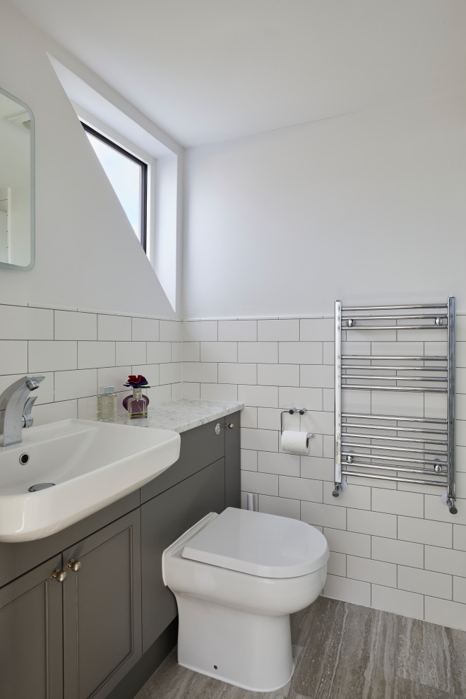 Inspiration för små moderna vitt en-suite badrum, med skåp i shakerstil, en toalettstol med hel cisternkåpa, vit kakel, keramikplattor, vita väggar, ett nedsänkt handfat, marmorbänkskiva och beiget golv