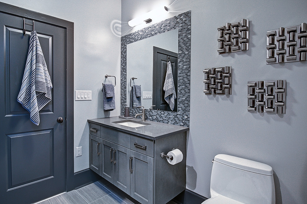 Idee per una piccola stanza da bagno con doccia contemporanea con lavabo sottopiano, ante in stile shaker, ante grigie, top in quarzo composito, piastrelle grigie, piastrelle di vetro, pareti grigie e pavimento in gres porcellanato