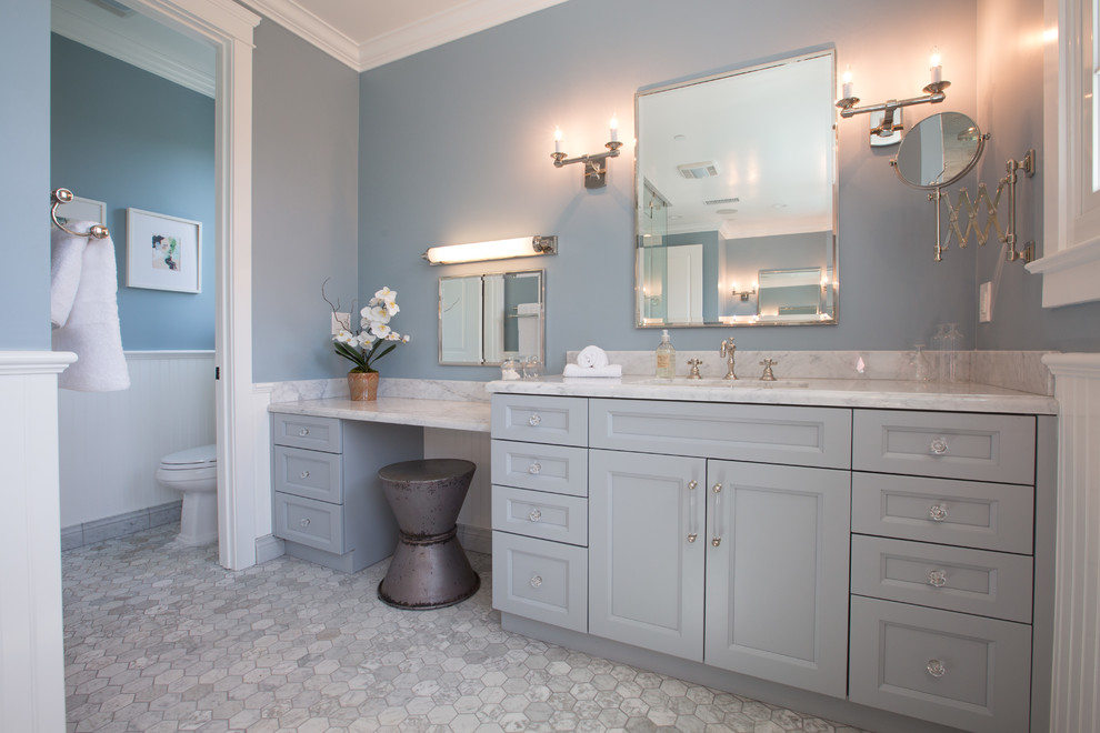 Bild på ett stort vintage en-suite badrum, med ett undermonterad handfat, luckor med infälld panel, blå skåp, marmorbänkskiva, ett fristående badkar, en hörndusch, en toalettstol med hel cisternkåpa, grå kakel, mosaik, blå väggar och marmorgolv