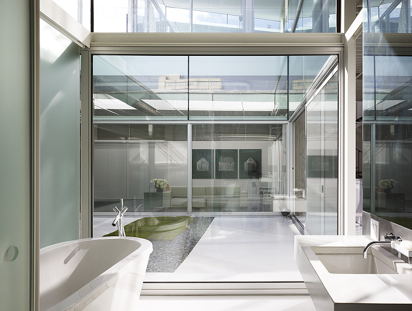 Industriell inredning av ett badrum, med ett fristående badkar och vitt golv