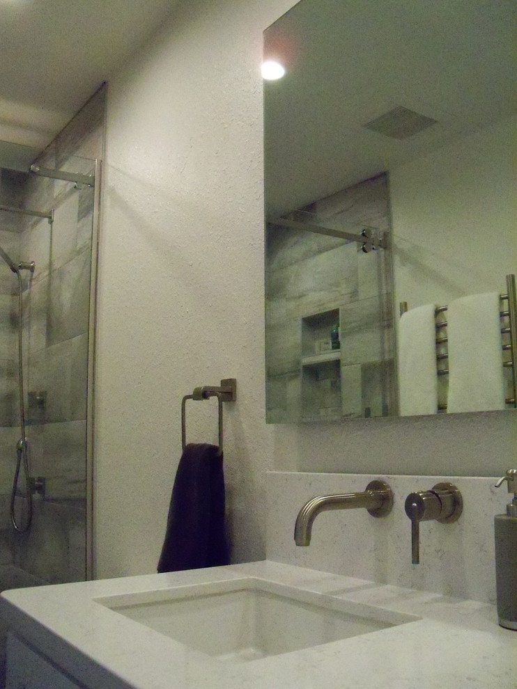 Inspiration för ett litet funkis en-suite badrum, med skåp i shakerstil, vita skåp, en dusch i en alkov, en toalettstol med hel cisternkåpa, grå kakel, porslinskakel, grå väggar, klinkergolv i porslin, ett undermonterad handfat, bänkskiva i kvarts och dusch med skjutdörr
