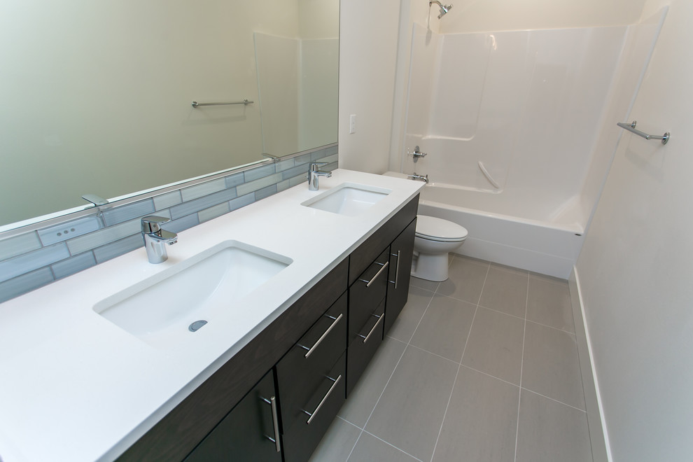Inspiration for a mid-sized modern gray tile and glass tile porcelain tile and gray floor bathroom remodel in Seattle with flat-panel cabinets, dark wood cabinets, a two-piece toilet, white walls, an undermount sink and quartz countertops