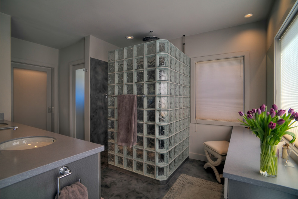 Bathroom - mid-sized contemporary master concrete floor, gray floor, double-sink and vaulted ceiling bathroom idea in Seattle with an undermount sink, flat-panel cabinets, gray cabinets, solid surface countertops, a two-piece toilet, gray walls, gray countertops and a built-in vanity