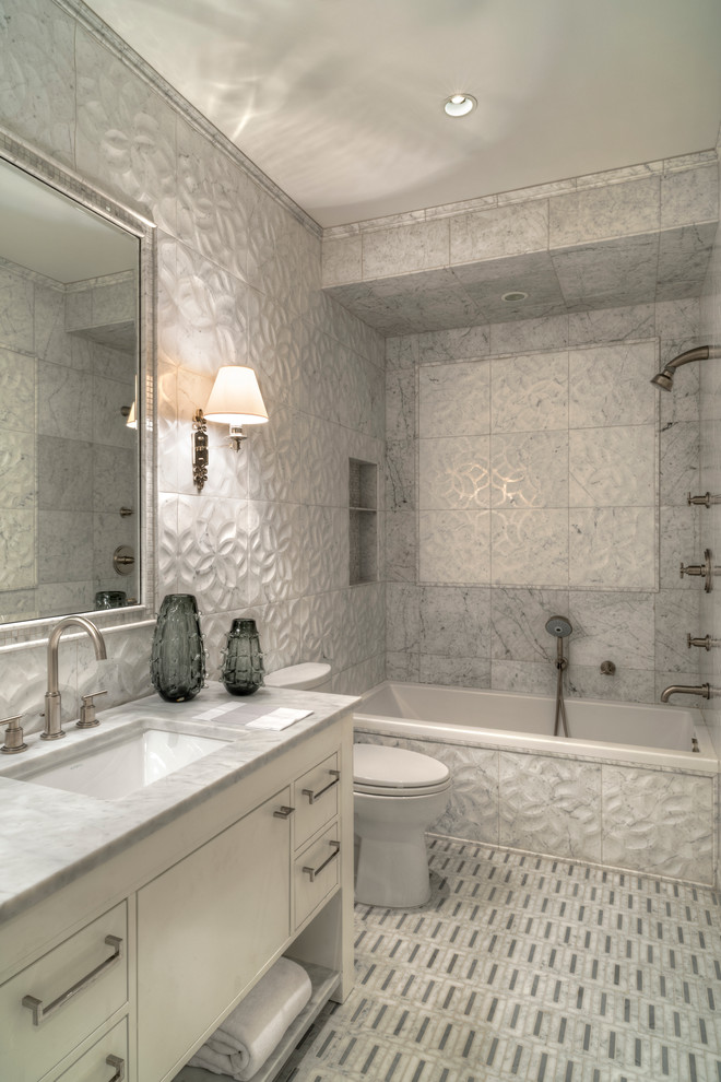 Small contemporary family bathroom in New York with a submerged sink, freestanding cabinets, beige cabinets, marble worktops, an alcove bath, an alcove shower, a one-piece toilet, grey tiles, stone tiles, grey walls and mosaic tile flooring.