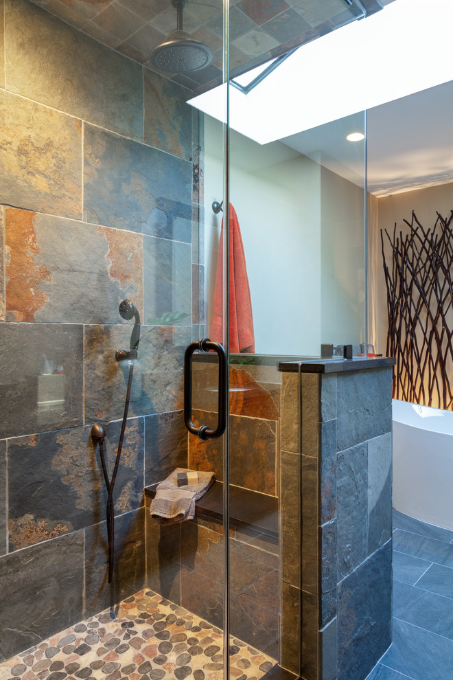 Cette photo montre une salle de bain principale montagne de taille moyenne avec une baignoire indépendante, une douche d'angle, du carrelage en ardoise, un mur beige, un sol en ardoise, un sol gris et une cabine de douche à porte battante.
