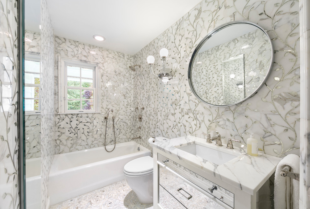 Example of an eclectic white tile and marble tile marble floor and white floor drop-in bathtub design in New York with glass-front cabinets, a two-piece toilet, white walls and a console sink