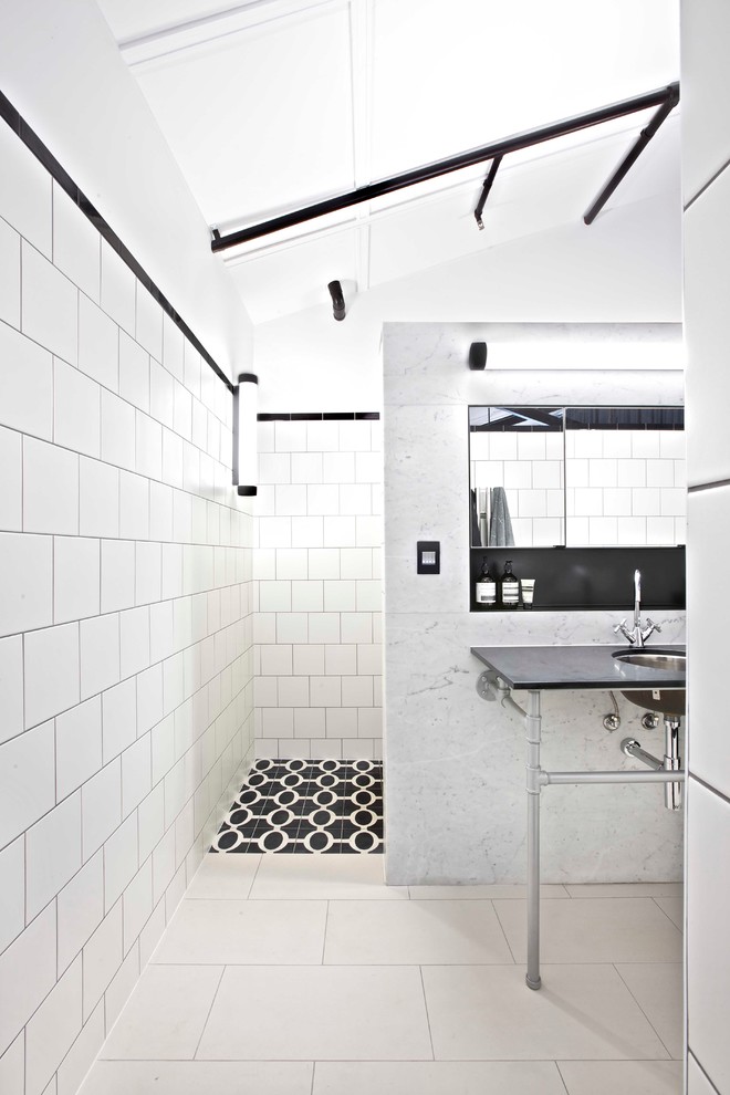 Exemple d'une grande salle de bain principale industrielle avec un placard avec porte à panneau encastré, WC suspendus, un carrelage blanc, des carreaux de céramique et un mur blanc.