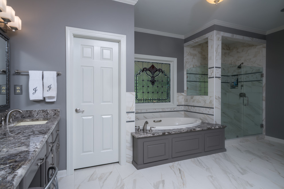 Inredning av ett klassiskt badrum, med luckor med upphöjd panel, grå skåp, granitbänkskiva, ett platsbyggt badkar, en hörndusch och flerfärgad kakel