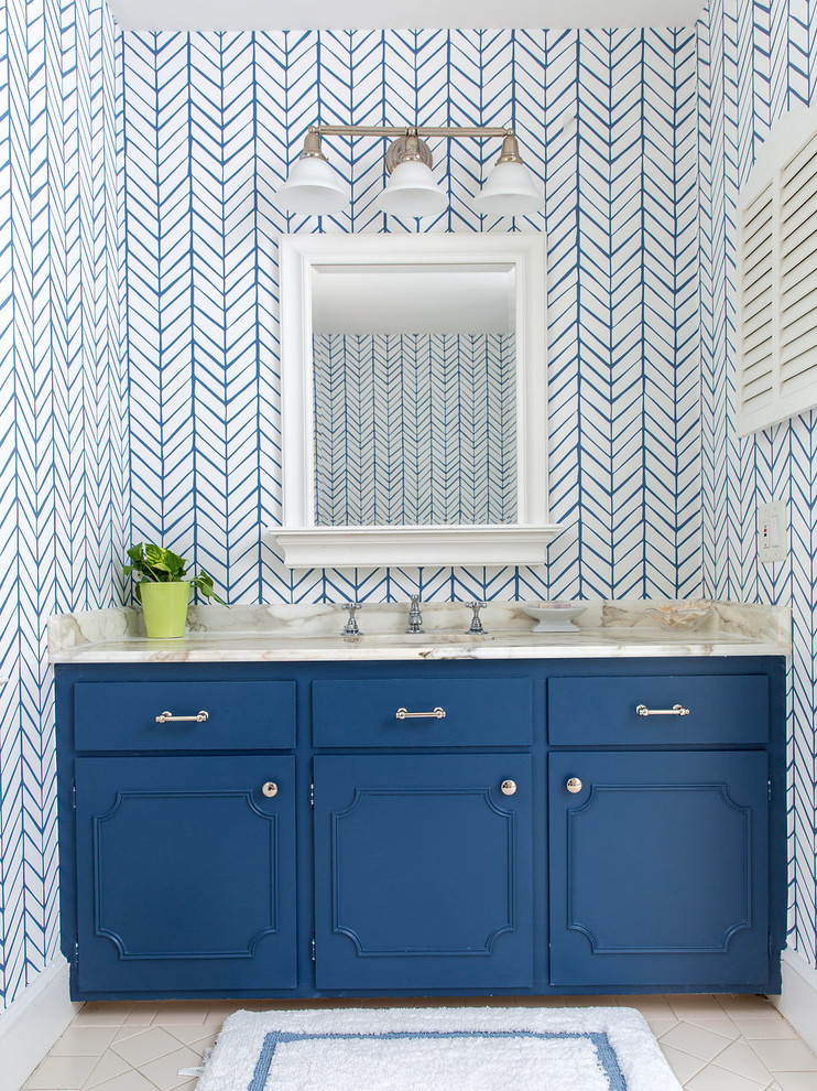 ローリーにあるトランジショナルスタイルのおしゃれな浴室 (青いキャビネット、マルチカラーの壁、アンダーカウンター洗面器、ベージュの床) の写真