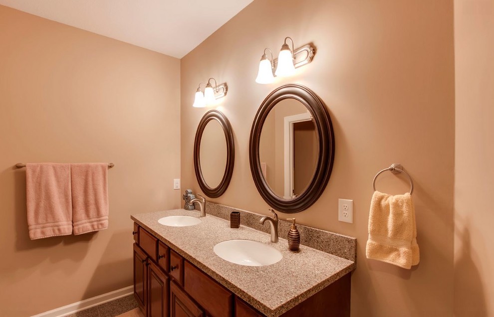 Example of a large classic master multicolored tile and stone tile bathroom design in Other with raised-panel cabinets, dark wood cabinets, a one-piece toilet, multicolored walls, an undermount sink and quartz countertops